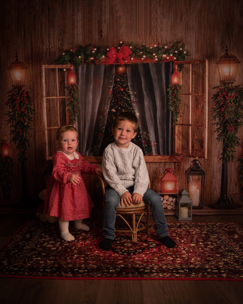 brother and sister on christmas photography backdrop