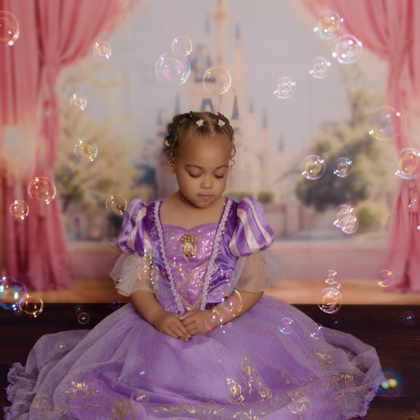 little girl dressed as princess surrounded by bubbles